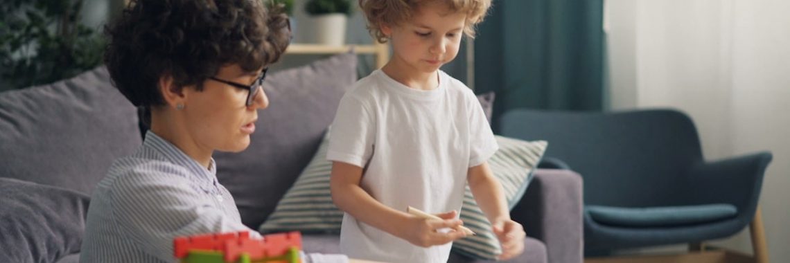 a woman and a child playing with blocks on a table